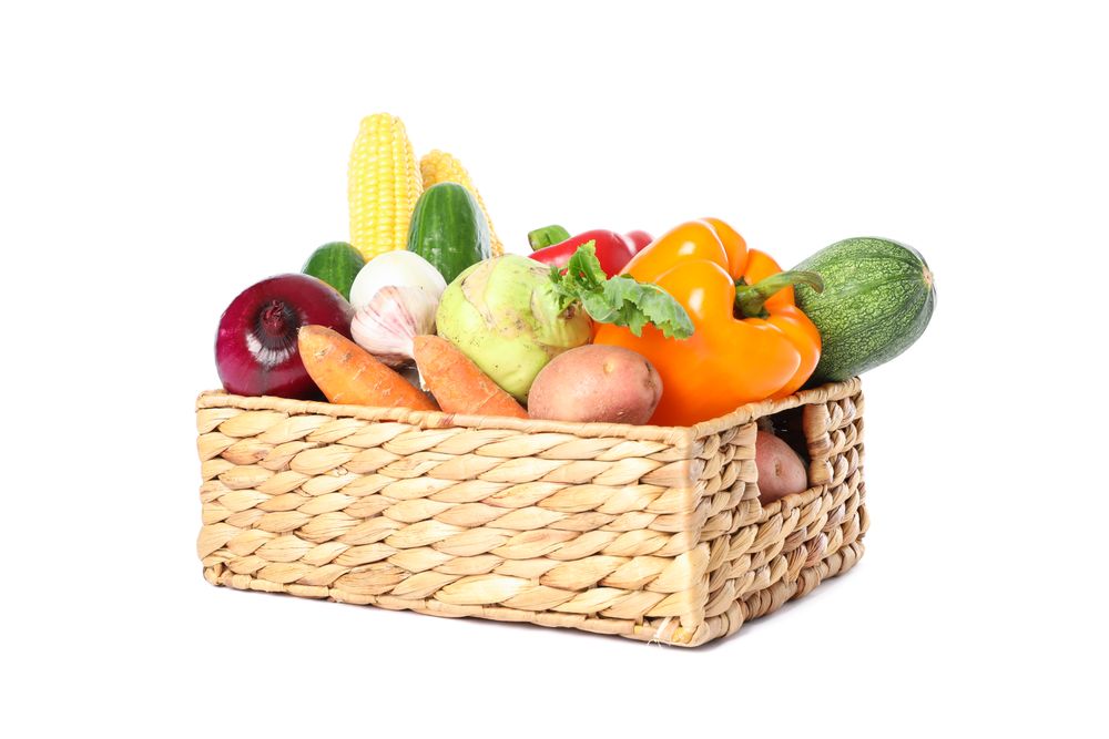 Wicker basket with vegetables isolated on blank background