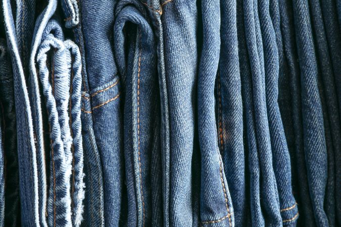 Stack of blue jeans as background, space for text