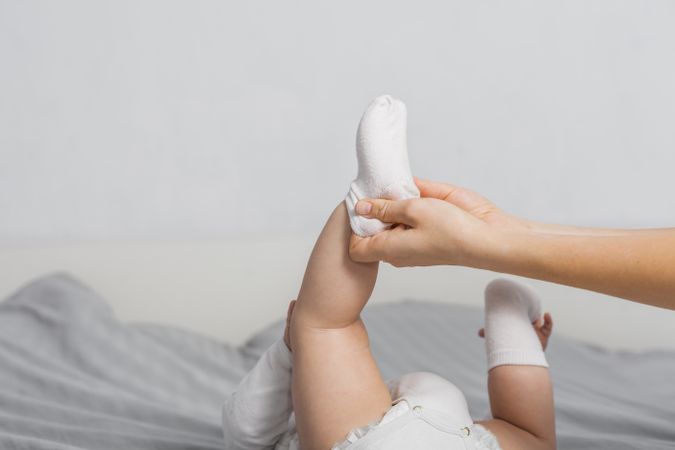 Woman putting socks on baby