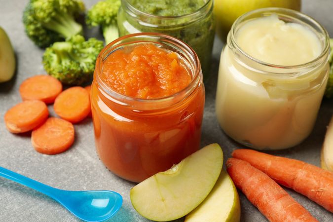 Composition with baby food on gray background, close up