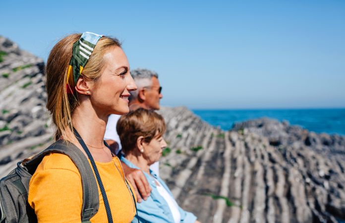 Daughter with her older parents enjoying view by the coast