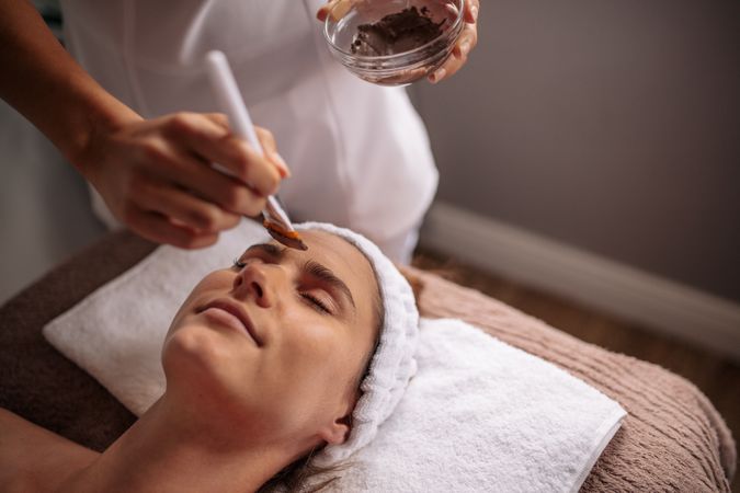Woman receiving facial mask in spa beauty salon