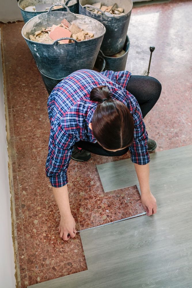 Unrecognizable female bricklayer measuring tiles to install a floor