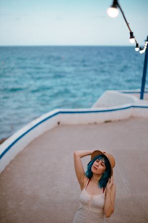Charming woman in sundress walking along pier