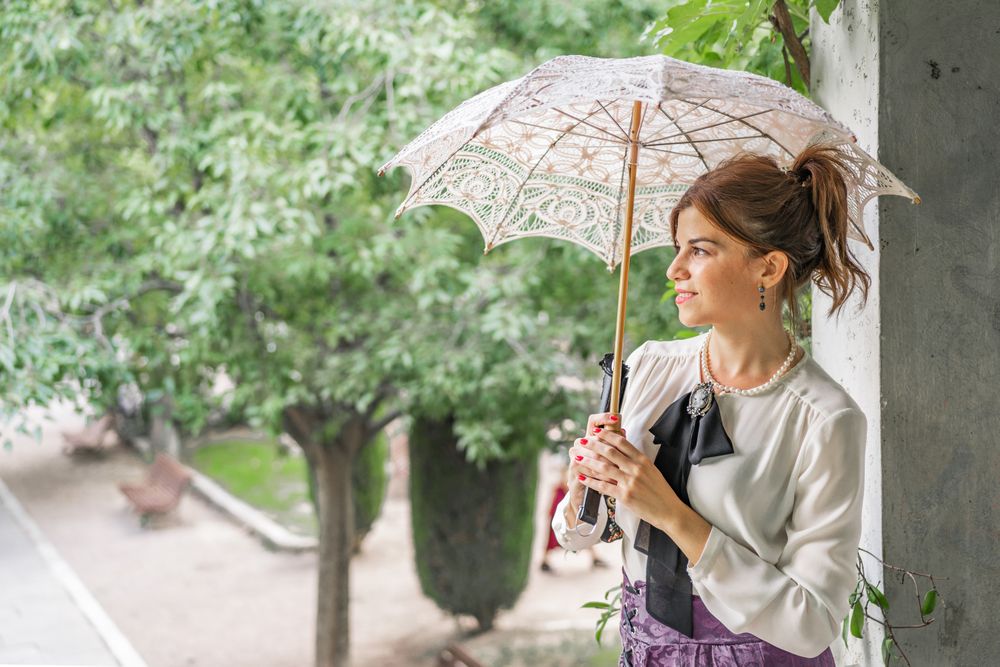 Vintage woman with parasol resting in garden