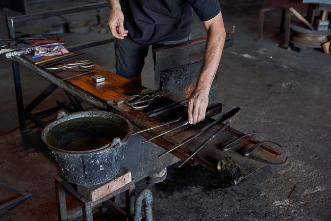 Master with various tools making glass in factory