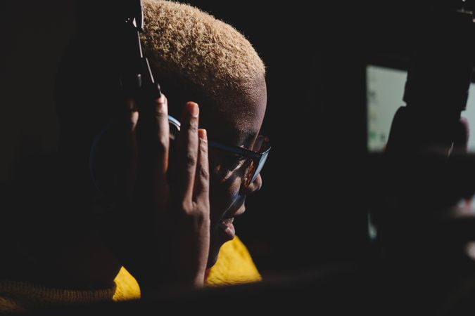 Black woman with headphones in dark room