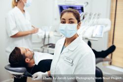 Dentist's assistant wearing face mask looking at camera 483QZ5