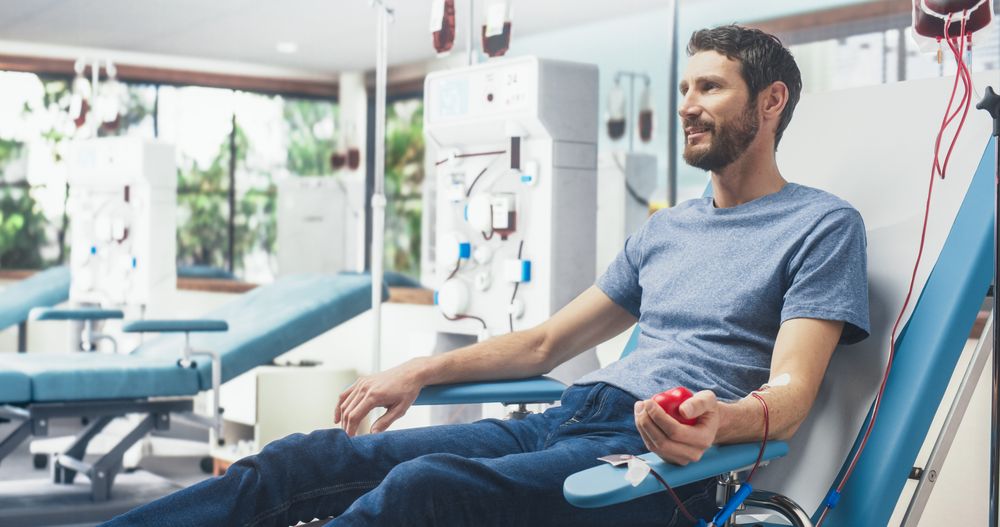 Man Donating Blood For People In Need In Bright Hospital.