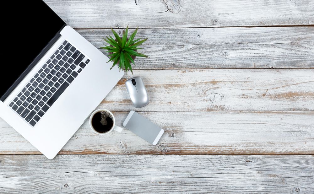 Top view of working desktop and dark coffee drink with plenty of copy space