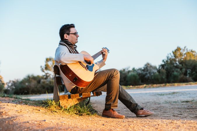 Man playing the guitar on the outside
