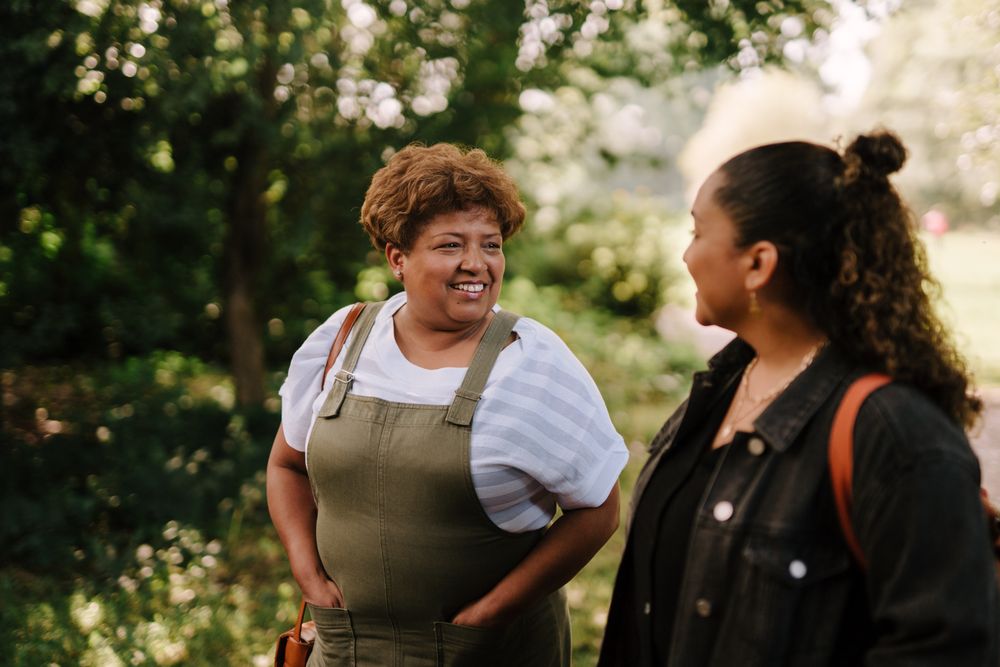 Two women smiling and talking while walking outside