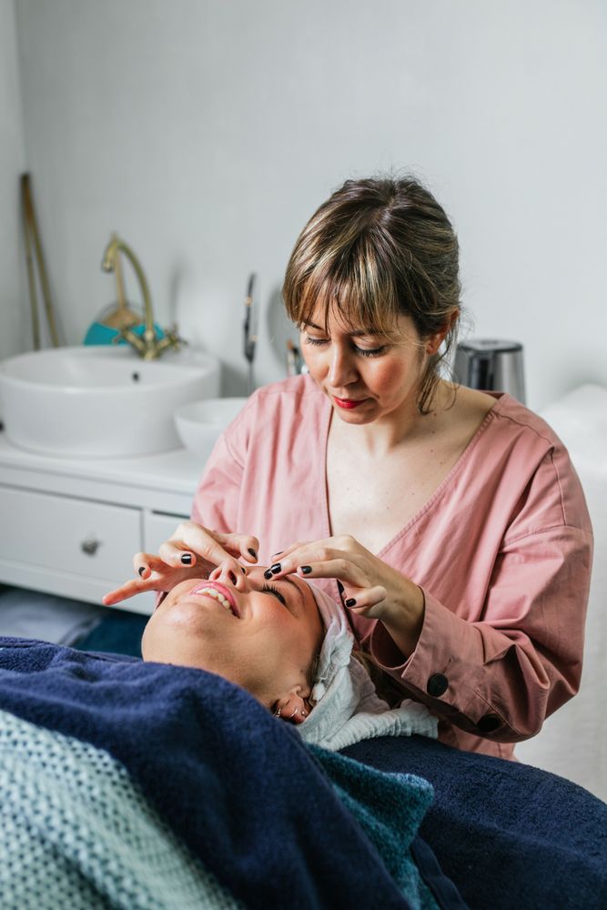 Smiling masseuse doing massage for woman in spa salon