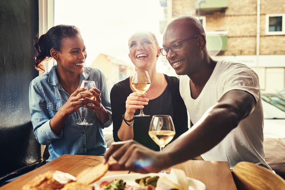 Three good friends drinking wine in a bright tapas restaurant