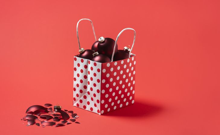 Christmas balls in a gift bag isolated on a red background