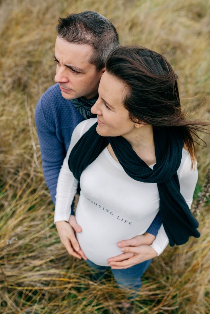 Pregnant couple hugging and holding belly