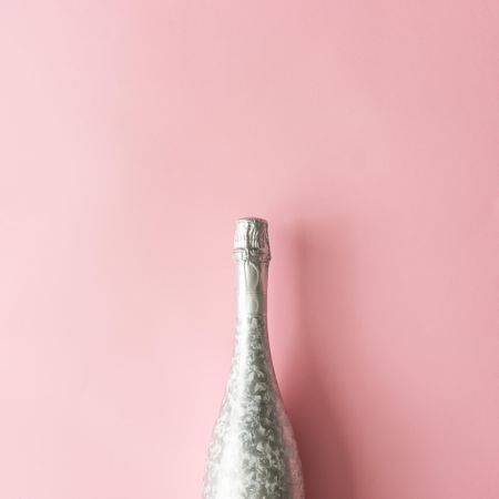 Silver Champagne bottle on pastel pink background