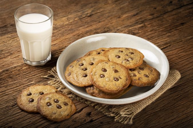 Delicious chocolate cookies with glass of milk on wooden table.