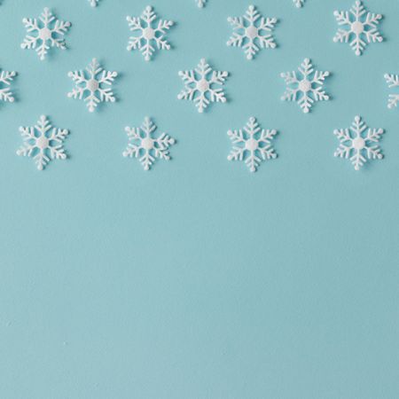 Winter pattern made of uniform snowflakes on blue background