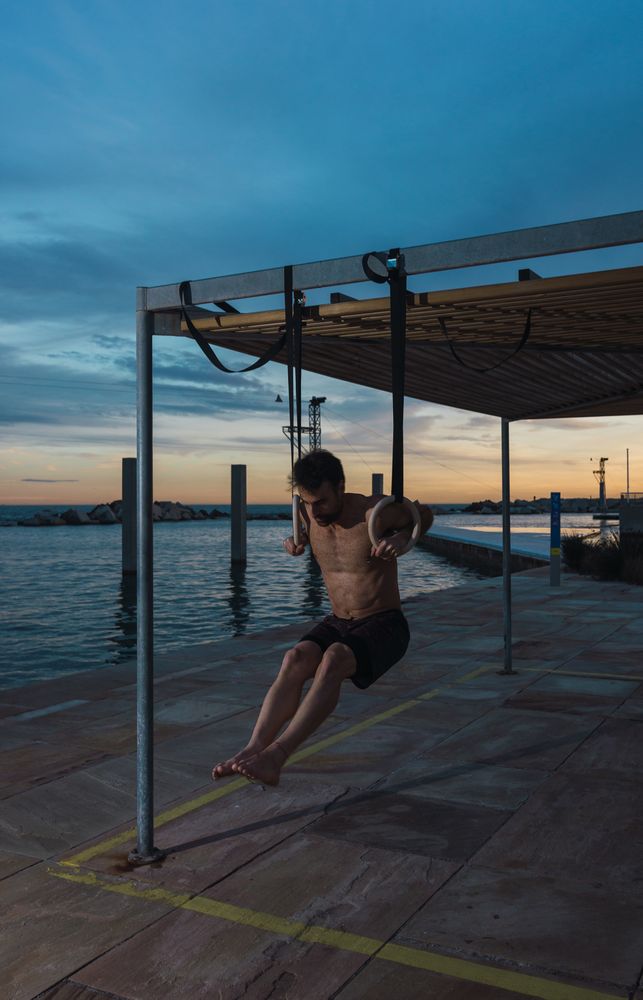 Athletic man balancing on gymnastic rings