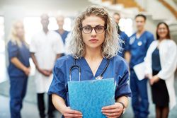 Portrait of blonde female doctor with her medical team in the background