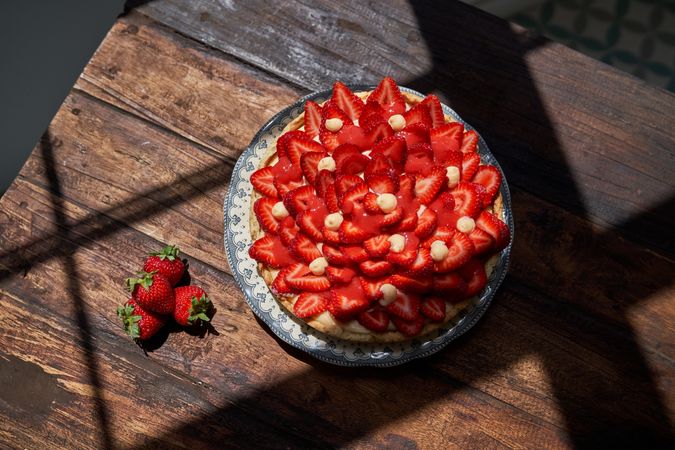 Plate with strawberries placed on wooden table