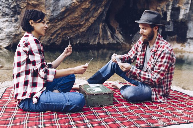 Casual couple playing cards on shore