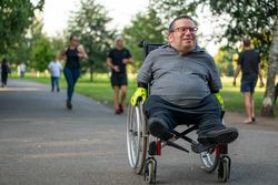 Man riding through park in wheelchair