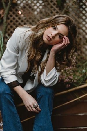 Woman sitting on planter in garden