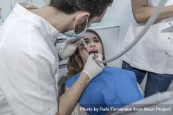 A portrait of a dentist examining female's mouth 4MQ8G4