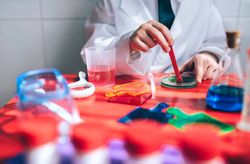 Boy's hands playing as a chemist with colorful liquids