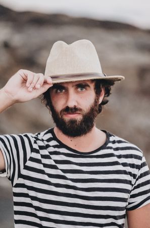 Bearded male in hat on deserted road