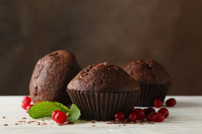 Composition with chocolate muffins and berries on wooden table