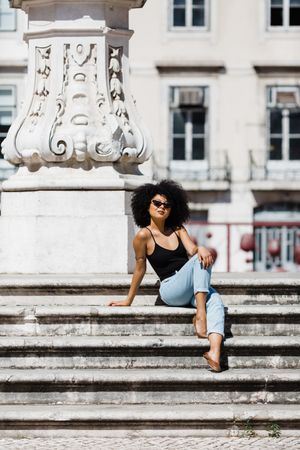 Black female siting on stairs outdoors
