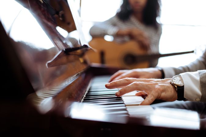 Crop male hands playing piano