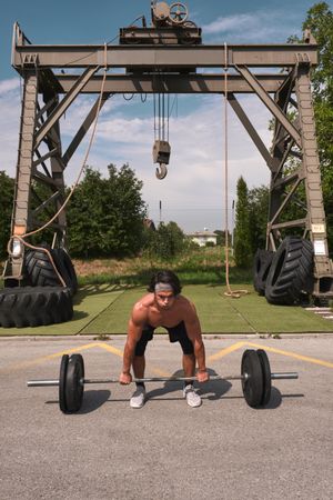 man with barbell in outdoor gym