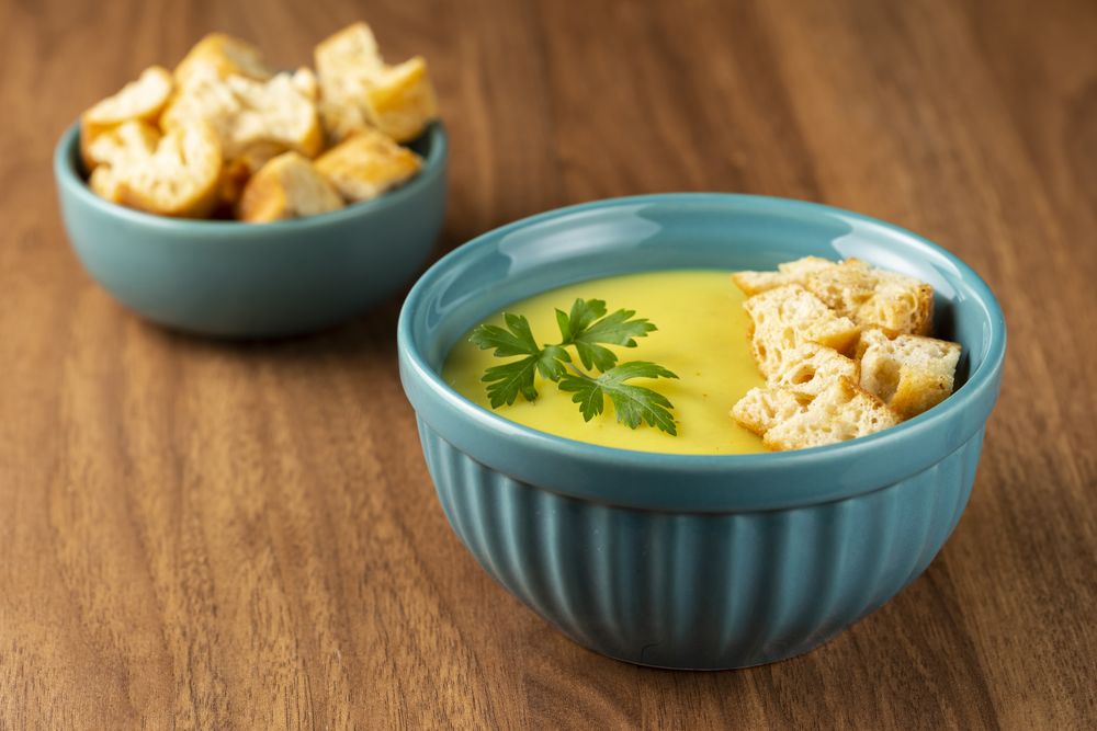 Bowl with onion soup and croutons on the table.