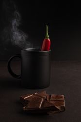Chocolate near mug with hot drink and pepper