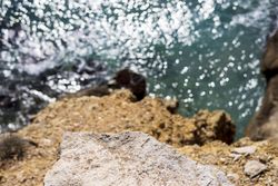 Looking down at water from above cliff