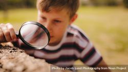 Boy with a magnifying glass at the park 5kWA35