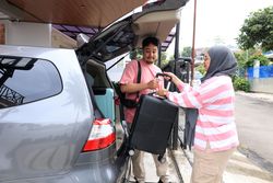 Indonesian Muslim Couple Loading Luggage to The Car Trunk