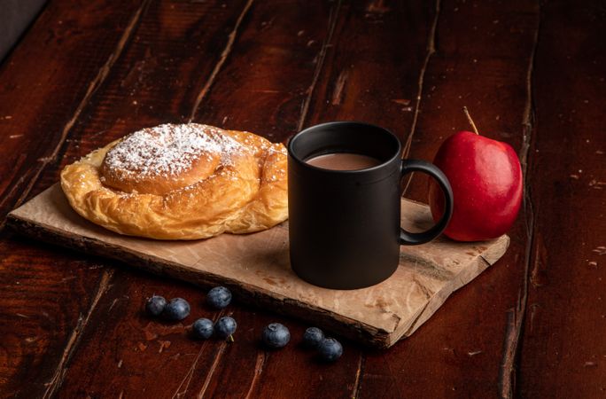 Fresh fruits near bun and hot drink