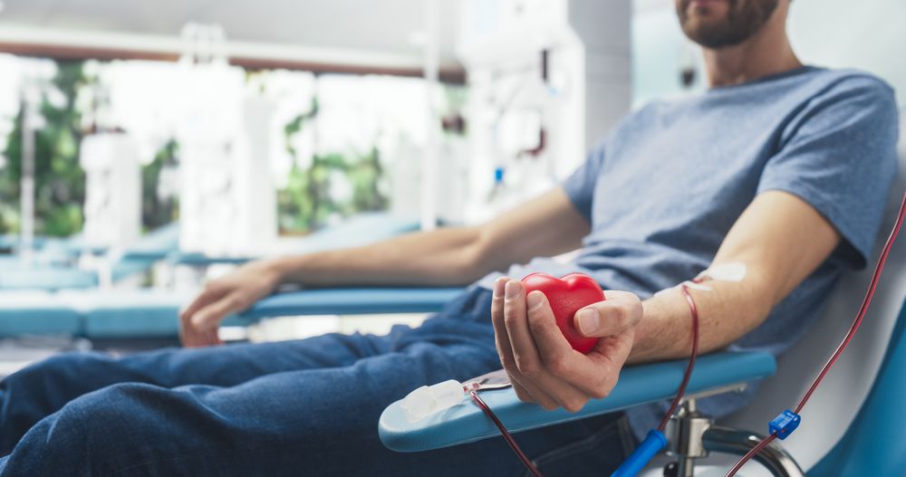 Close Up Shot Of Hand Of Male Blood Donor With an Attached Catheter.