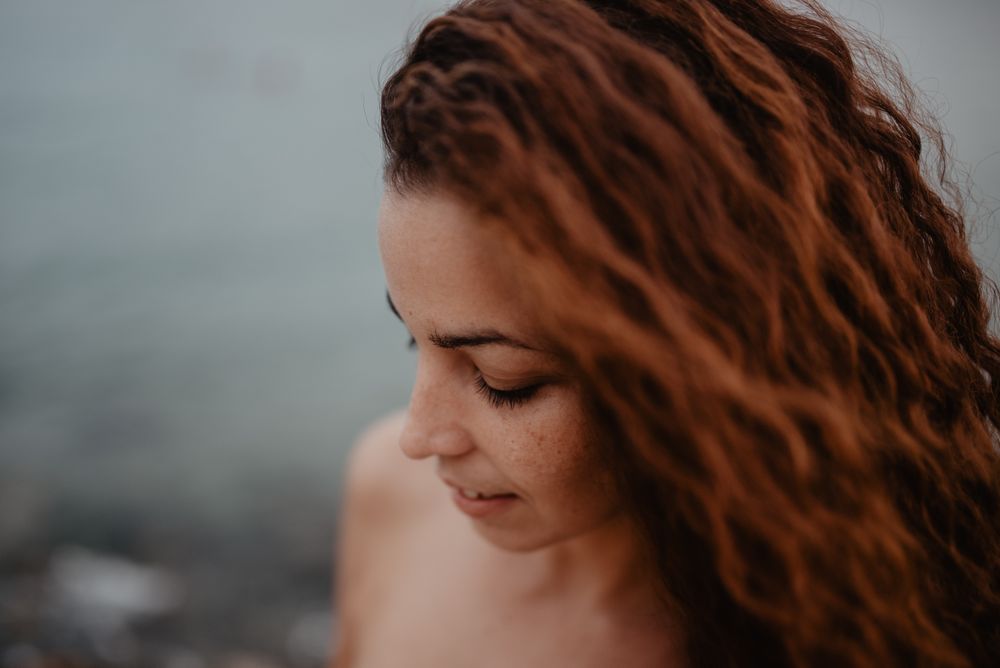 Smiling red-haired woman looking down