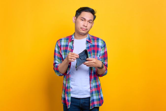 Asian man showing inside of his empty wallet