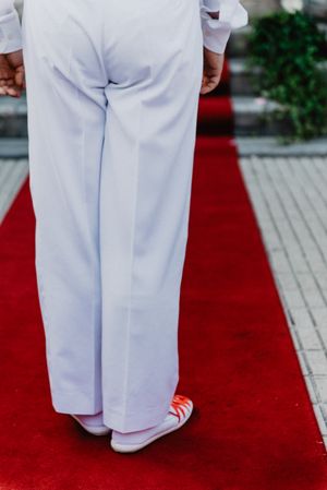 Person in  gym shoes jumping on red carpet