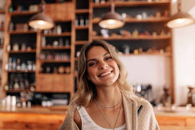 Young female in a coffee shop with a beautiful smile on her face