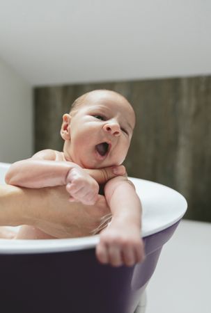 Newborn yawning in the bathtub