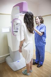 Doctor examining breast of female patient