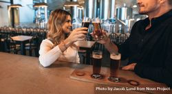 Young woman and man toasting with beer sample glasses 48WMj5